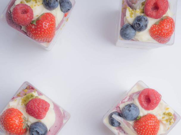 Yoghurtwoestijn met frambozen, bramen, aardbeien en noten - Foto, afbeelding