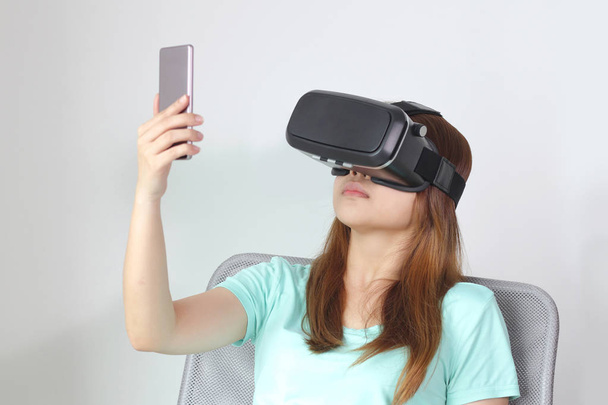 Jeune femme portant des lunettes de réalité virtuelle à la maison
. - Photo, image