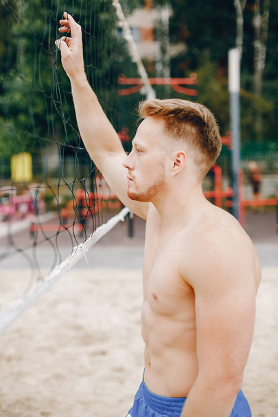 Handsome man training in a summer park - Photo, image