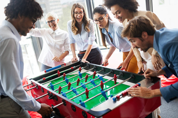 Business people having great time together.Colleagues playing table football in modern office. - 写真・画像