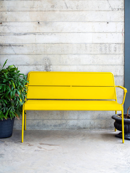 Современная желтая скамейка на бетонном фоне
 - Фото, изображение