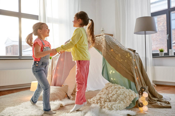 happy girls playing near kids tent at home - Φωτογραφία, εικόνα