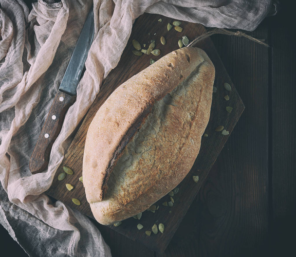 baked crisp oval bread and vintage knife - Photo, Image
