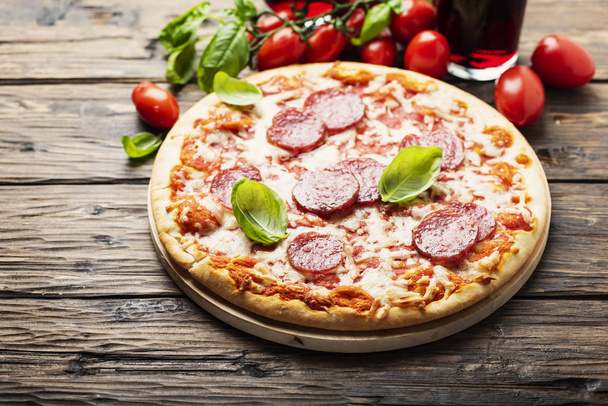 Pizza italiana con tomate y salami
 - Foto, Imagen
