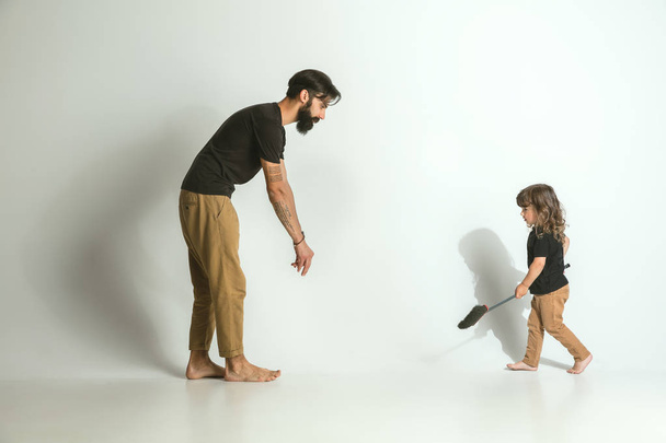白いスタジオの背景に対して若い息子と遊ぶ父 - 写真・画像