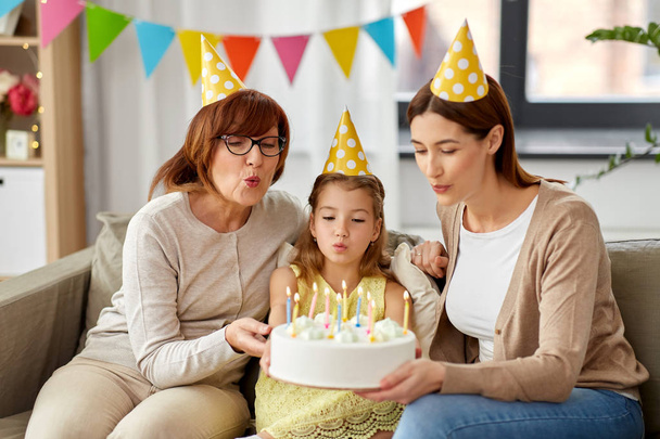 mother, daughter, grandmother with birthday cake - Foto, afbeelding