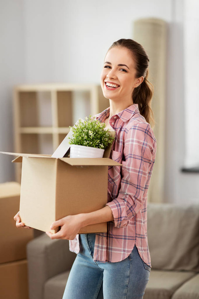 happy woman with stuff moving to new home - Фото, изображение
