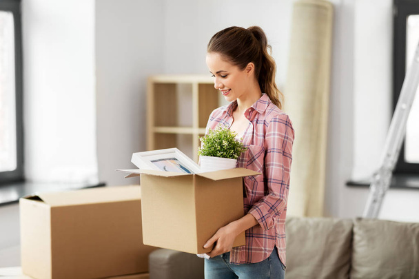 happy woman with stuff moving to new home - Фото, изображение