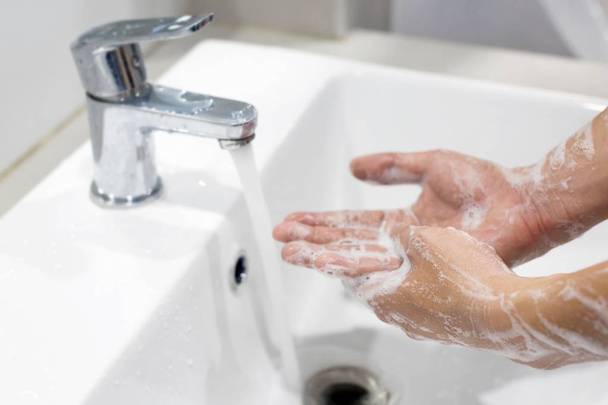 衛生だ。手を洗え。水で蛇口の下に石鹸で手を洗う. - 写真・画像