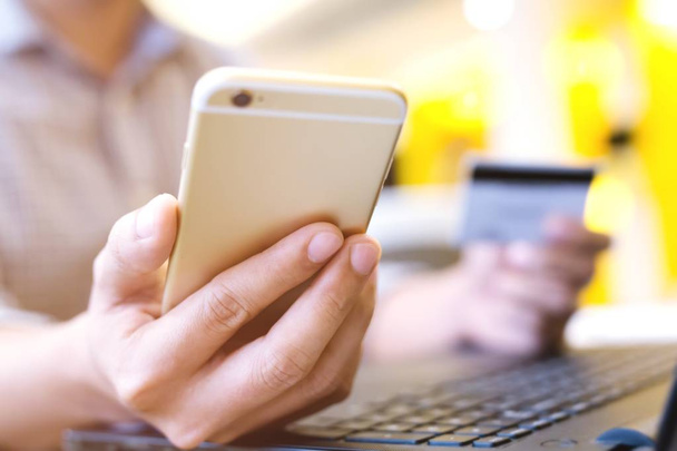 teendő ember kezek tárolás hitelkártya és használ telefon és számítógép laptop. Online vásárlás vásárlása eladás vagy fizetés. - Fotó, kép