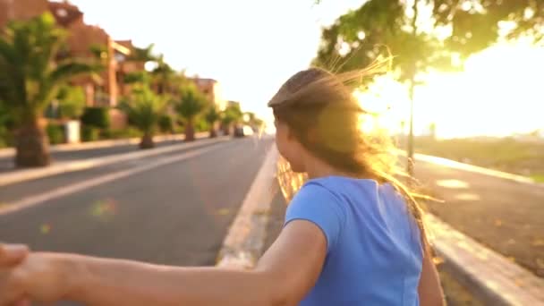 Следуйте за мной - счастливая молодая женщина тянет парней за руку - рука об руку работает в яркий солнечный день. Медленное движение
 - Кадры, видео