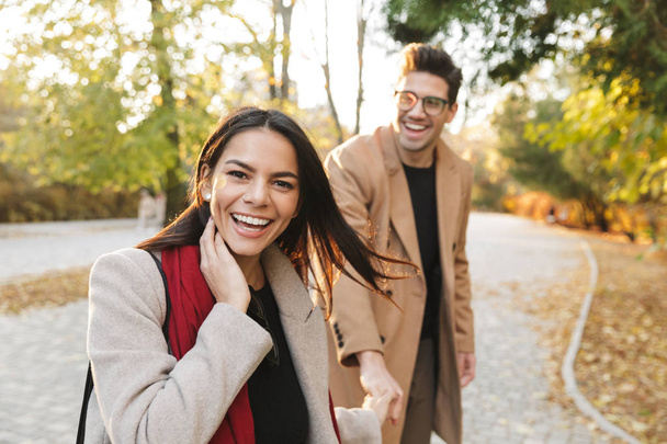 Happy young couple wearing autumn coats - Fotografie, Obrázek