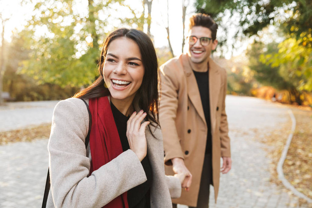 Happy young couple wearing autumn coats - Фото, изображение