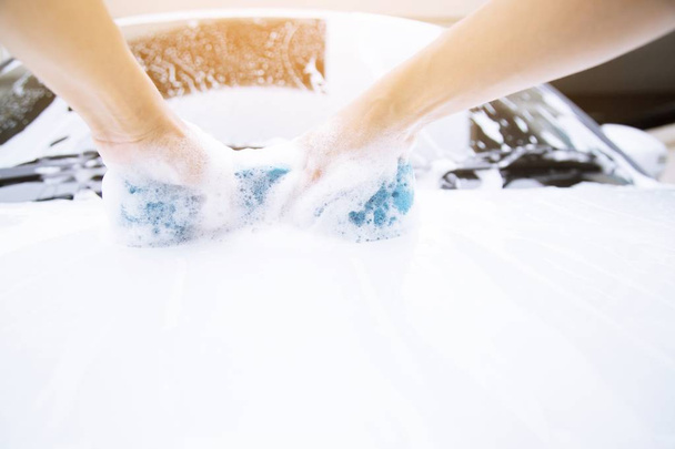 Female hand with blue sponge clean washing car side mirror. concept car wash. - Zdjęcie, obraz