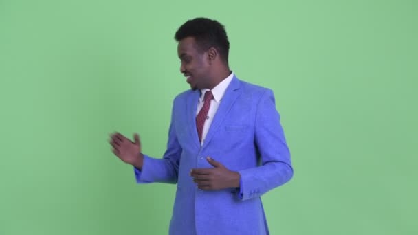 Happy young African businessman explaining something - Felvétel, videó