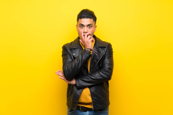 Young man over isolated yellow background surprised and shocked while looking right - Photo, image
