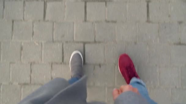 男性と女性の足を歩道に沿って散歩の平面図です。コーヒーを飲む女性 - 映像、動画