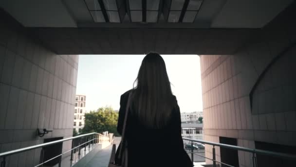 Follow shot of young professional businesswoman walking outdoors - Imágenes, Vídeo