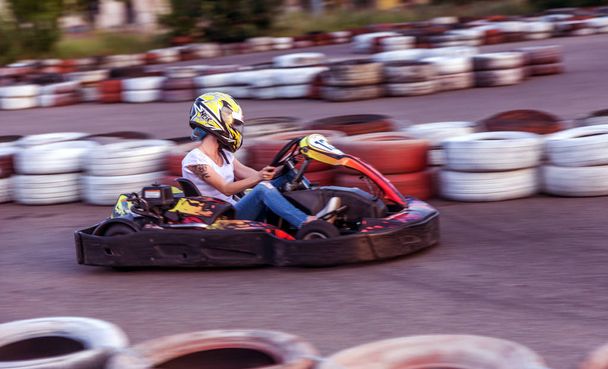 ODESSA, UKRAINE - June 19, 2019: karting. Racers on races on special safe high-speed tracks limited by car tires. Attraction High-speed ride in carts. Sport karting entertainment - Foto, Bild