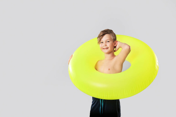 Cute little boy with inflatable ring on grey background - Photo, Image