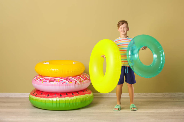 Cute little boy with inflatable rings near color wall - Foto, imagen