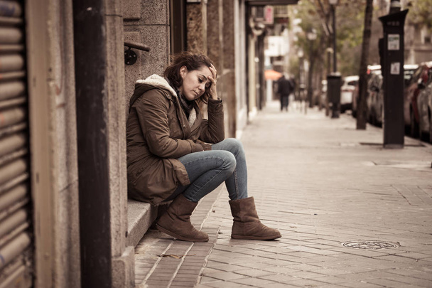 Attractive woman suffering from depression felling sad unhappy heartbroken and lonely sitting in city urban street in Mental health Emotional pain Abusive relationships and loneliness concept. - Fotoğraf, Görsel
