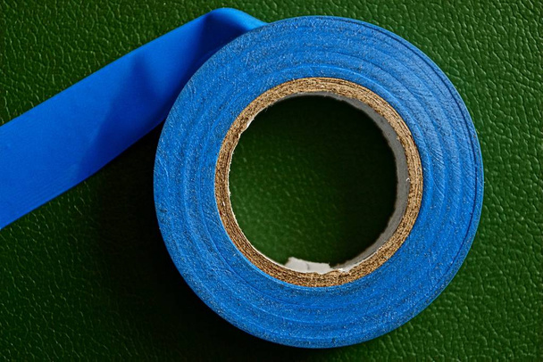 Blue industrial insulating tape on a green surface - Photo, Image