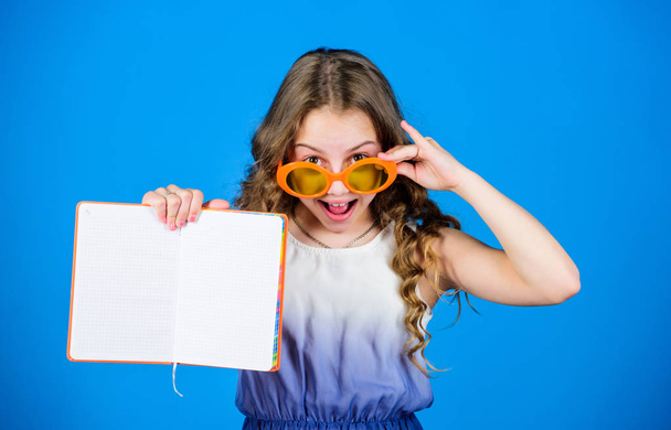 reading book. Summer fashion. small beauty girl write her memories. diary notes. making plans for summer holidays and vacation. small happy girl in glasses with notebook. copy space. secret story - Foto, imagen