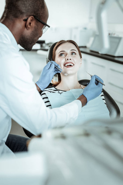 Ginger tidy woman having dentist appointment and showing her teeth - Foto, afbeelding