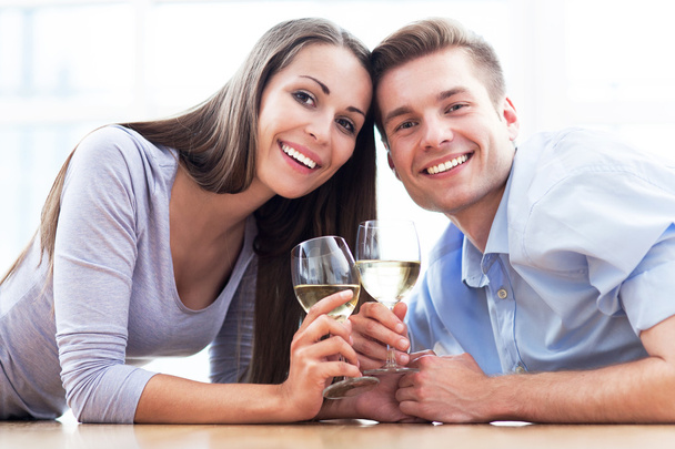 Couple drinking wine in modern apartment - Фото, изображение