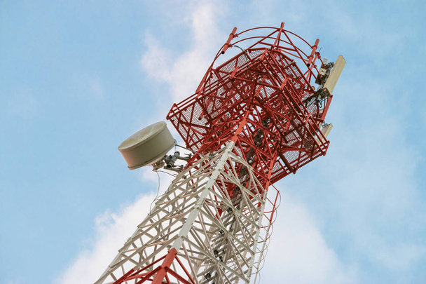 Антенный передатчик беспроводной связи. Телекоммуникационная башня с антеннами на голубом фоне неба
.  - Фото, изображение