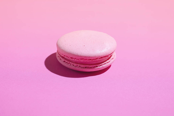 Single macaron dessert isolated on pink background. - Фото, изображение