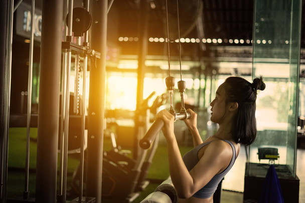 Sport achtergrond. Gespierde fit vrouw trainen in fitness gym. - Foto, afbeelding