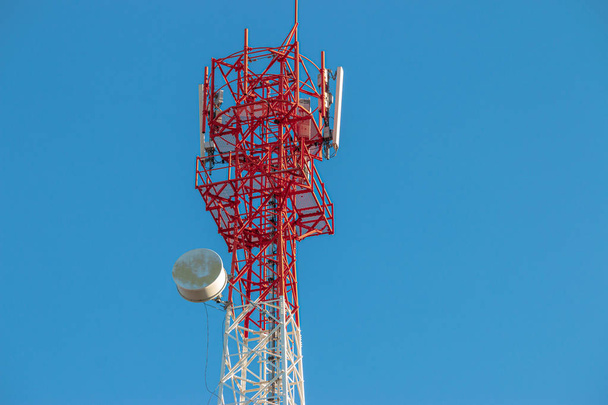 Vezeték nélküli kommunikációs antenna adó. Távközlő torony antennákkal kék ég háttér.  - Fotó, kép