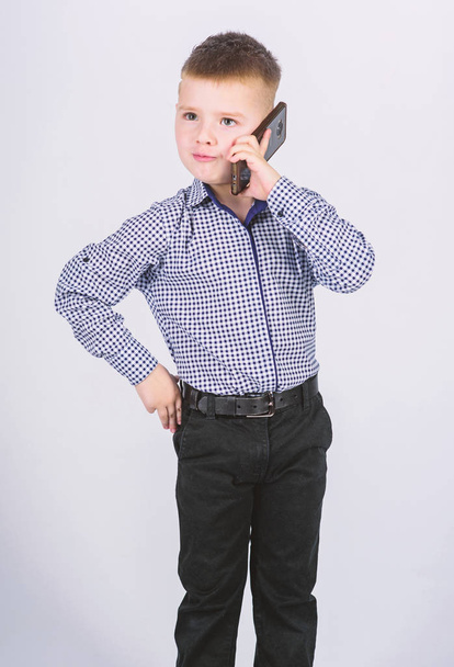 Mobile communication. Modern gadget. Small businessman. Upbringing and development. Little boy formal clothes call mobile phone. Cute boy hold smartphone. Mobile conversation. Business school - Valokuva, kuva