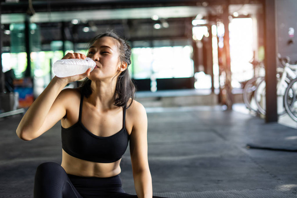 Спортивная красивая женщина упражнения расслабиться и пить воду с тра
 - Фото, изображение