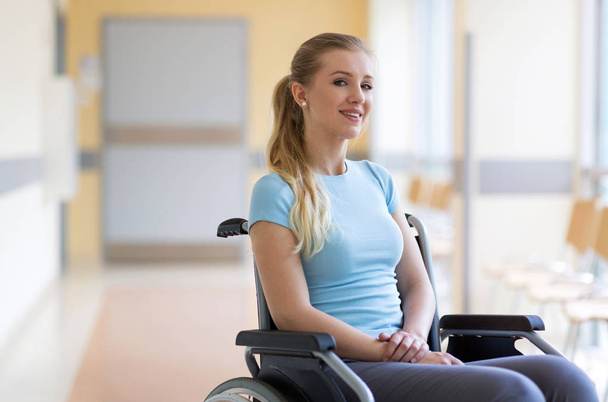 Portrait of young woman sitting in her wheelchair - Фото, изображение