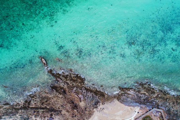 Aerial top view of ocean waves, beach and rocky coastline and be - Фото, зображення