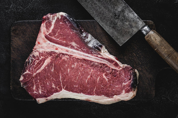 T-bone Steak Raw Dry Aged Beef on Vintage Cutting Board - Foto, Bild