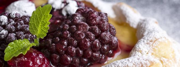 Vanilla Cream and Fruit Berry Puff Pastry Dessert Sprinkled with Powdered Sugar on Dark Background - Foto, Imagem