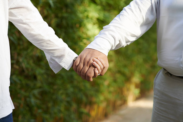 Cropped image of aged couple holding hands when walking outdoors - Фото, зображення