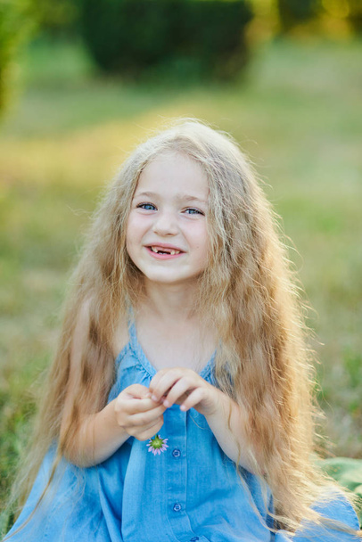 Close up portret pięknej, radosnej blondynki białej dziewczyny uśmiechającej się demonstrując białe zęby bez dwóch przednich zębów. Wesołe dziecko. - Zdjęcie, obraz