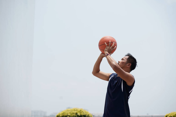 フィリピンのバスケットボール選手がジャンプしてボールを投げる - 写真・画像