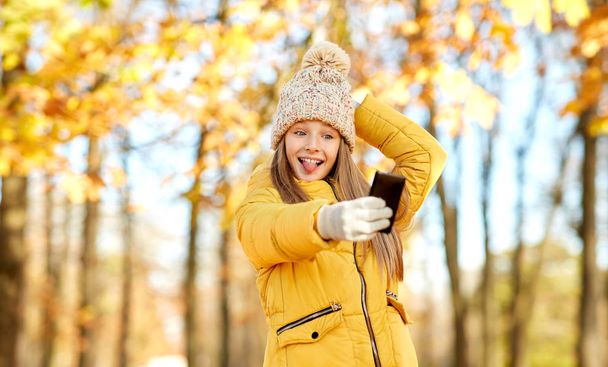 girl taking selfie by smartphone at autumn park - Foto, Bild