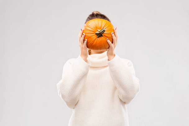 woman holding pumpkin and covering her face - Foto, Bild