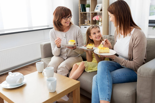 mother, daughter and grandmother eating cake - 写真・画像