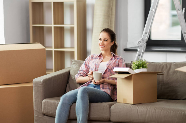 woman moving to new home and drinking coffee - Foto, imagen
