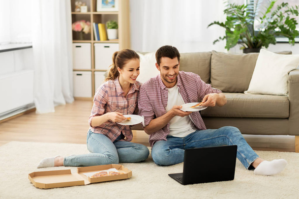 happy couple with laptop eating pizza at home - Φωτογραφία, εικόνα