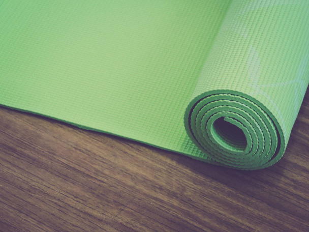  topo view.Healthy vida, manter em forma concepts.Equipment para ioga. Top vista verde tapete de ioga esporte isolado.Rolou-se tapete de ioga isolado no branco. Espaço de cópia
.  - Foto, Imagem