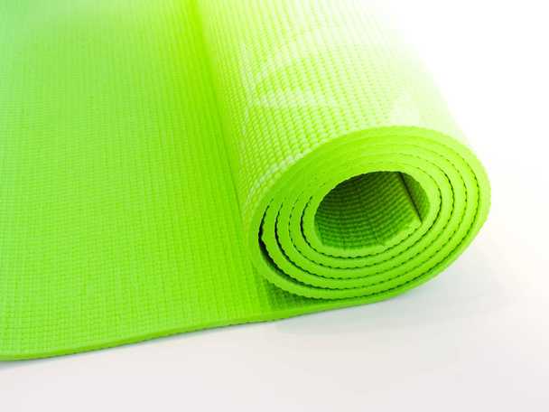 Opgerold yoga mat geïsoleerd op wit. Copyspace.  - Foto, afbeelding